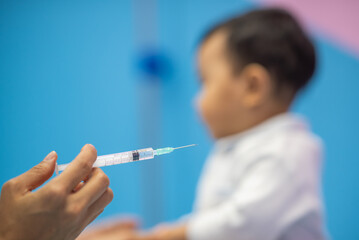pediatrician Hand hold vaccine liquid injection in syringe for injecting child baby infant. small syringe needle for infant prevention flu by vaccination immunity in Pediatrics hospital clinic.