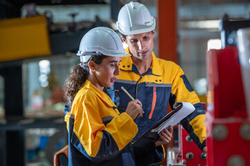 two young engineer assistant in helmet inspection check heavy machine construction installation ...