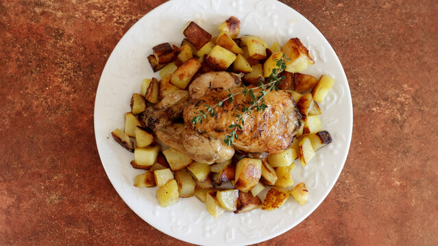 coquelet r&ocirc;ti et pommes de terre rissol&eacute;es dans une plat	