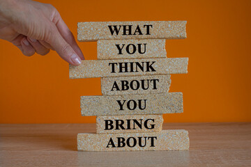 Think about bring about symbol. Brick blocks with words What you think about you bring about....