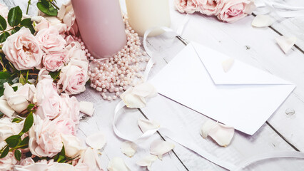 Bouquet of flowers roses of the valley and letter on wooden table from above, top view, flat lay