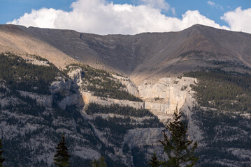 Incredible nature scenery outside of Banff National Park during summer time with iconic Three Sisters in view on sunset, golden hour afternoon. 
