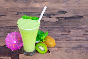 Kiwi yogurt fruit juice smoothie green colorful fruit juice milkshake blend beverage healthy high protein the taste yummy In glass drink episode morning on wood background.