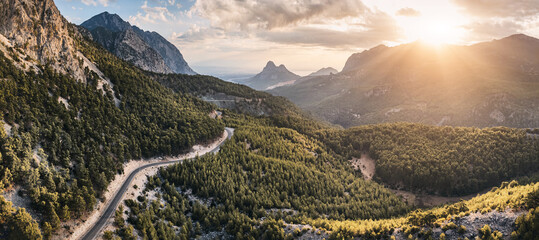 Aerial view of a scenic asphalt road in mountains in Turkey at majestic sunset with golden light