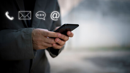 Businessman using Smart Phone with the email, call phone, address, Chat message icons.Customer support hotline Contact us people connection.