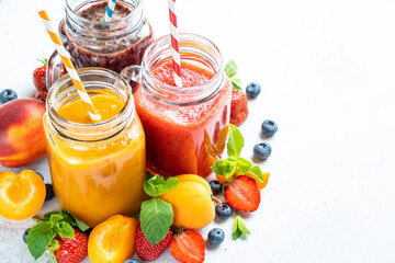Smoothie set with fresh fruits and berries at white background. Homemade healthy drink.
