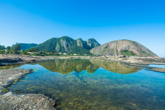 View of the beautiful Itacoatiara Beach and it's cliff reflected in the water - Niter&oacute;i, State of Rio de Janeiro, Brazil