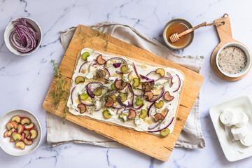 Tarte flambee with rhubarb, red onions, goat cheese and honey, prepared for baking, marble...