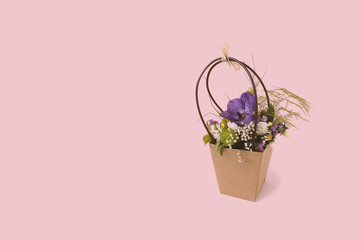 Beautiful gift box with flower on pink background with copy space. Concept of internet shopping, flower shop.