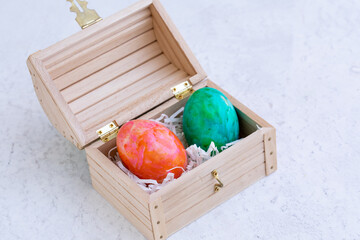 Two colored eggs in a small wooden box