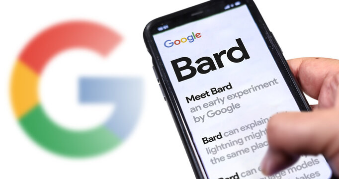 A hand holding a phone with the Google Bard website on the screen