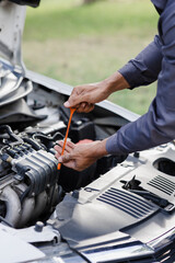 A mechanic checks the engine oil level. off-site car service.