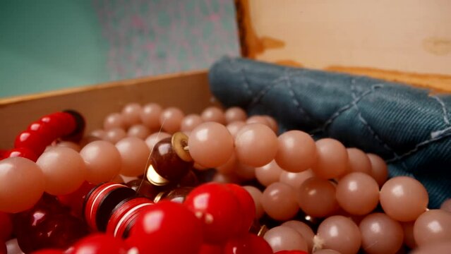 vintage coral beads and necklace in old wooden jewelry box, macro view, moving shot