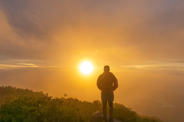 silhouette of a person walking on a hill at sunset
