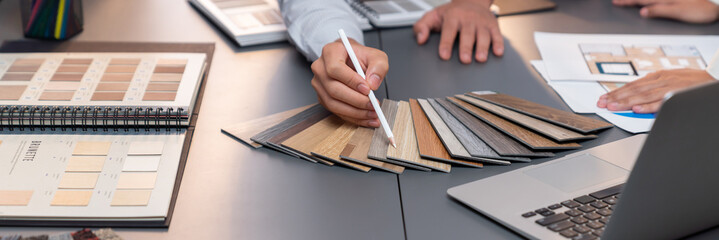 Group of interior designer team in meeting, discussing with engineer on interior design and planning for house project blueprint and model, choosing various mood board materials. Insight