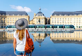 Fotobehang Rear view of woman looking at water mirror on bourse square in Bordeaux- France © M.studio