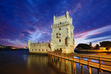 Belem Tower or Tower of St Vincent - famous tourist landmark of Lisboa and tourism attraction - on the bank of the Tagus River Tejo after sunset in dusk twilight with dramatic sky. Lisbon, Portugal