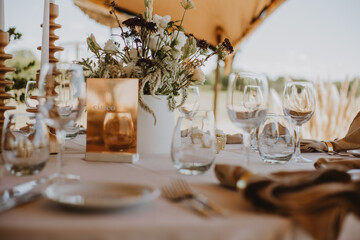 table setting with cup of wine, candles and flowers in a wedding
