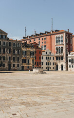 Fototapeta na wymiar View of city square with old facades of buildings and old water tank in the middle for fresh water