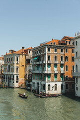 View of channel with  boats passing on clear water and colorful buildings 