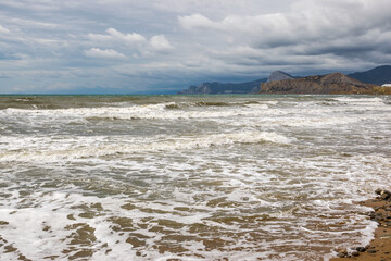 Foamy sea surf in cloudy weather
