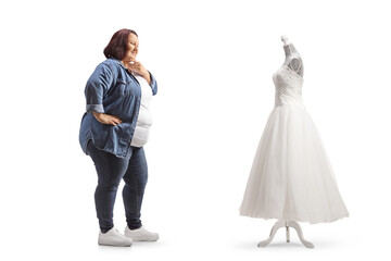 Casual corpulent woman looking at a bridal gown and thinking