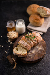 Sliced artisan baguette bread on wooden coaster and rustic background. Sourdough bread.