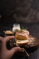Sliced artisan baguette bread on wooden coaster and rustic background. Sourdough bread.