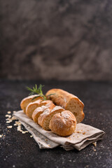 Sliced artisan baguette bread on wooden coaster and rustic background. Sourdough bread.