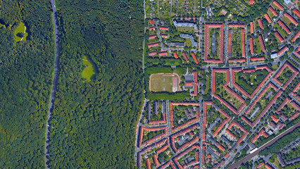 Forest and city border, forest and city separated by straight line, looking down aerial view from...