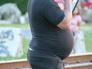 A man with a distended belly in black clothes
