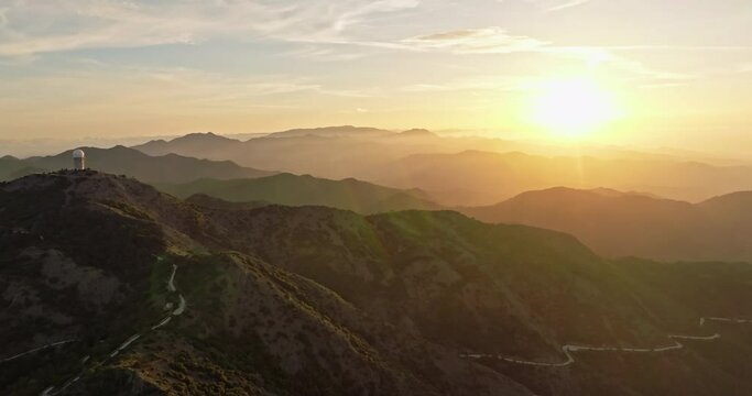 Aerial view of the advance of the sunset in the mountains. Beautiful untouched nature with forests on mountain slopes in the landscape. High quality 4k footage