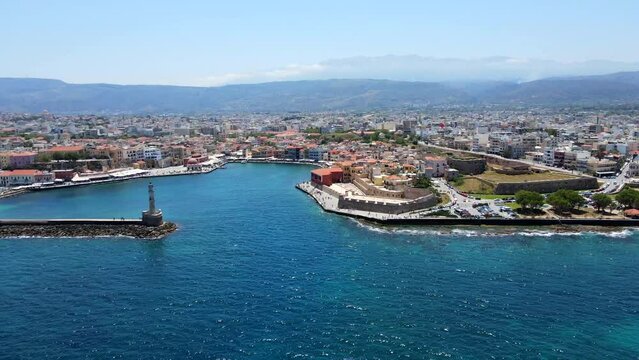 Aerial shot drone flies toward port and seaside fortress in Chania, Crete, Greece