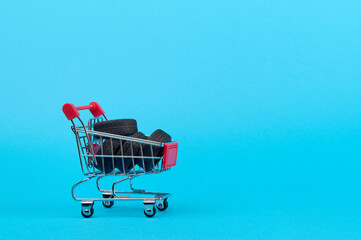 A pile of four tires in a supermarket cart on a blue background.