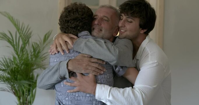 Young sons embracing their father with love