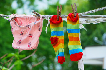 female underwear and socks air drying on the clothes line outside in the backyard