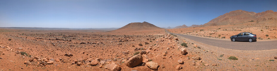 Panoramic desert landscape in the Souss-Massa region, a car driving on a road