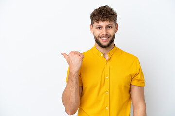 Young handsome caucasian man isolated on white background pointing to the side to present a product