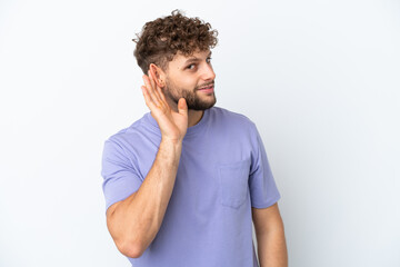 Fototapeta na wymiar Young handsome caucasian man isolated on white background listening to something by putting hand on the ear