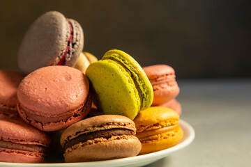 Close-up of macarons cakes of different colors in blue background. Culinary and cooking concept. Tasty colourful macaroons.