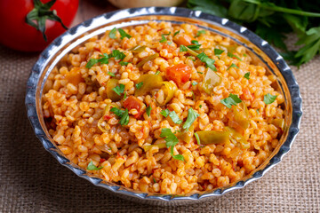 Traditional turkish bulgur pilaf with tomato sause in plate (Turkish name; meyhane pilavi)