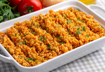 Traditional turkish bulgur pilaf with tomato sause in plate (Turkish name; meyhane pilavi)