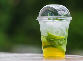 A plastic stand with a cool mojito drink (ice, mint, sparkling water, lime) in the afternoon