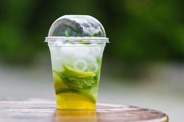 A plastic stand with a cool mojito drink (ice, mint, sparkling water, lime) in the afternoon