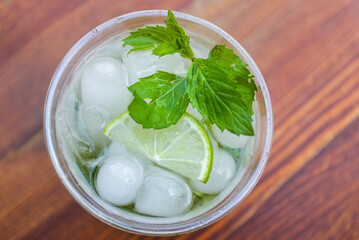 A plastic stand with a cool mojito drink (ice, mint, sparkling water, lime) in the afternoon
