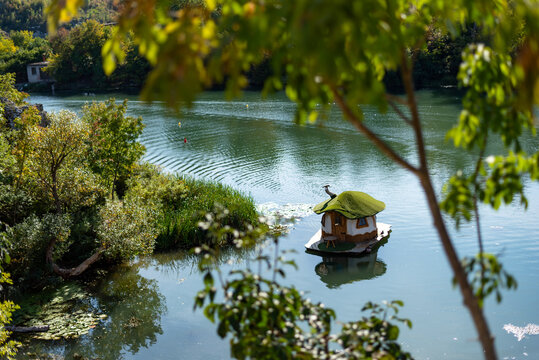 A beautiful scenery of small house in a lake in Golden park (Zlaten park) in Lukovit, Bulgaria. Duck swim in lake.