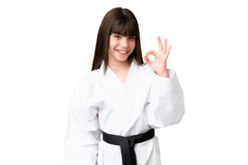 Little Caucasian girl doing karate over isolated background showing ok sign with fingers