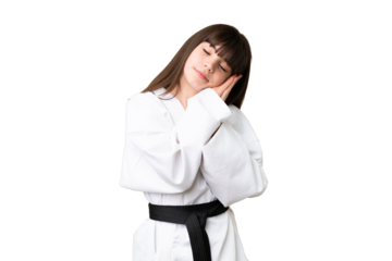 Little Caucasian girl doing karate over isolated background making sleep gesture in dorable expression