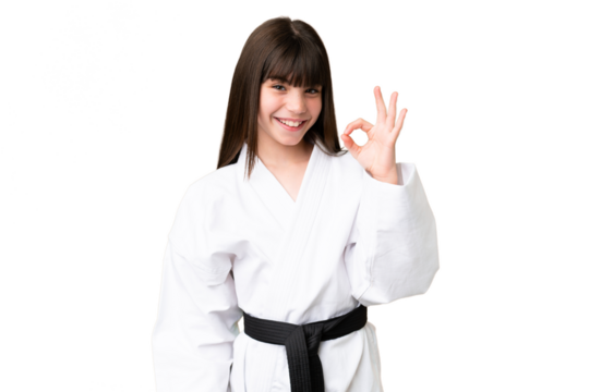Little Caucasian girl doing karate over isolated background showing ok sign with fingers