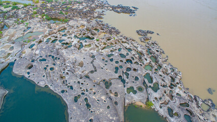 aerial photography around grand canyon in Mekong river. .3000 bok mean 3000 holes,holes eroded into the rock along Mekong river. .color of water inside the holes after low tide is emerald green